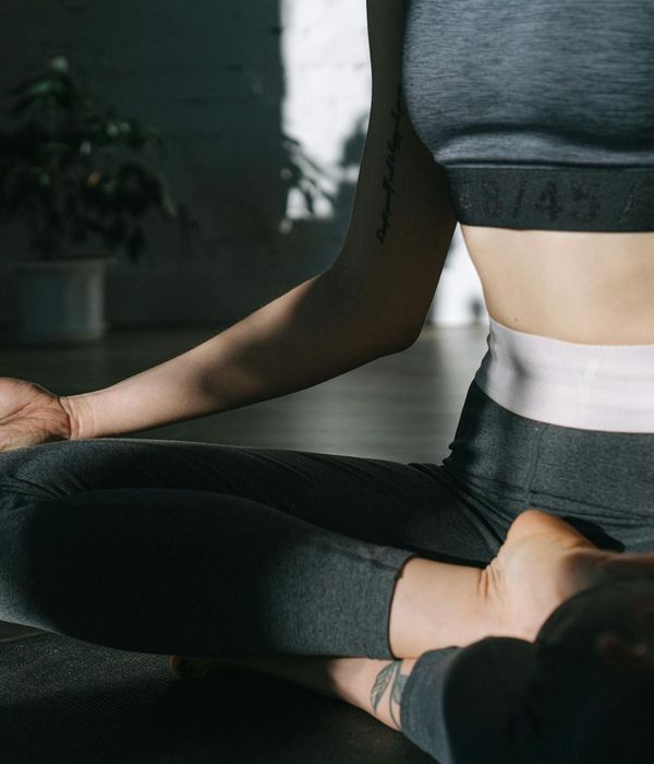 Woman in a serene yoga pose in a bright, minimalist room.